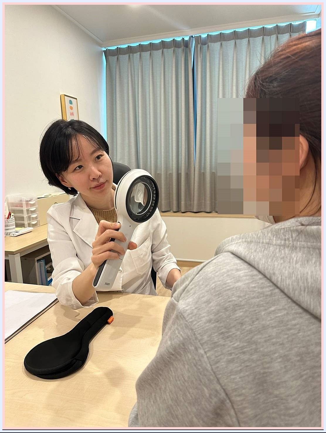 현미경으로 피부를 바라보는 원장님 사진